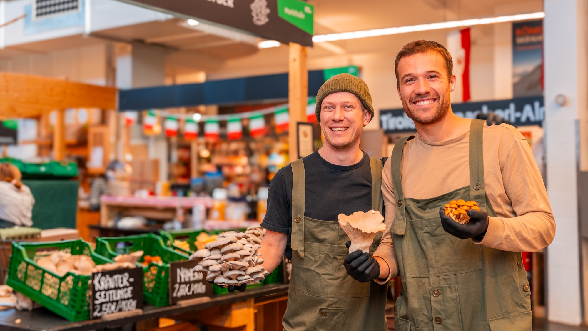 Siebe und Max von Pom Pilz mit frischen Edelpilzen am Marktstand in der Markthalle Innsbruck
